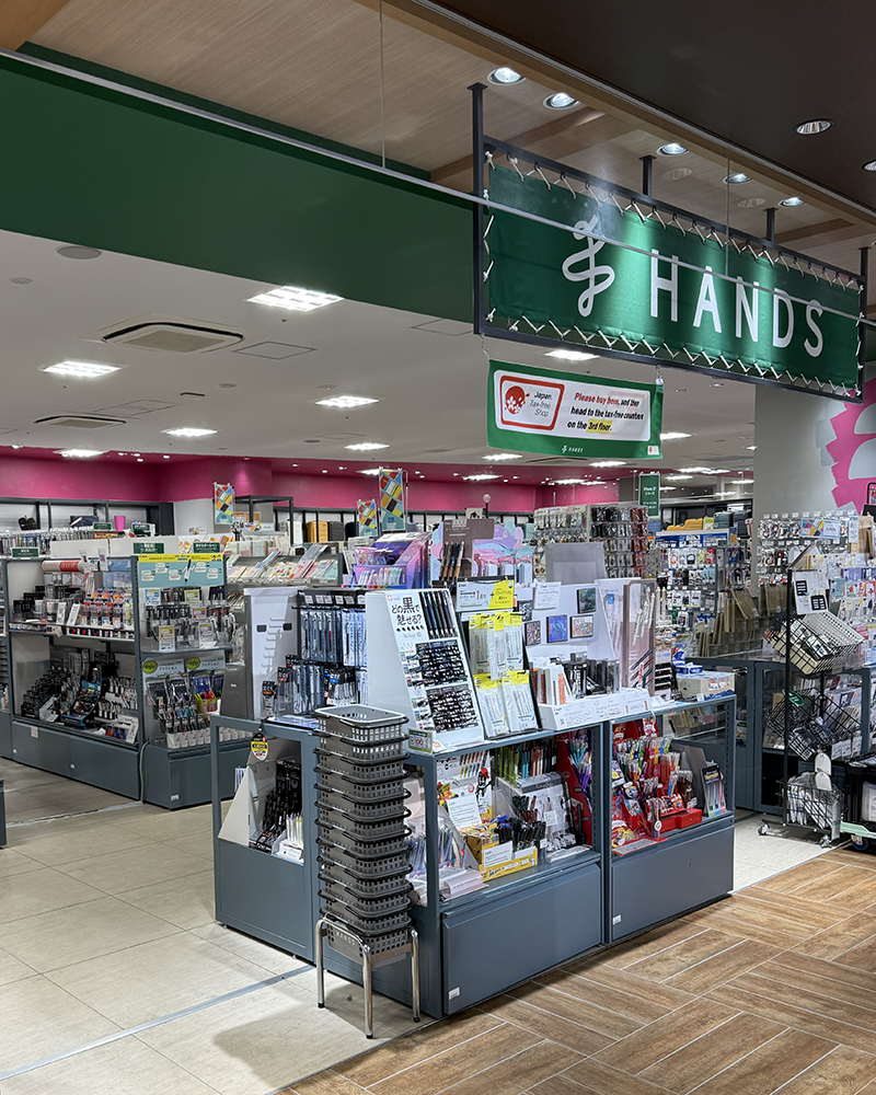 Picture of Hands (a home goods, health and beauty and stationery store). Pictures of pens and notebooks on shelves