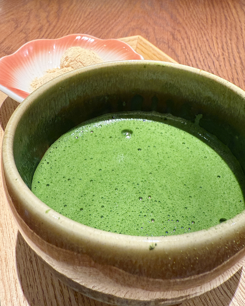 Matcha in a tea bowl at Fujii Meien on a wooden tray.