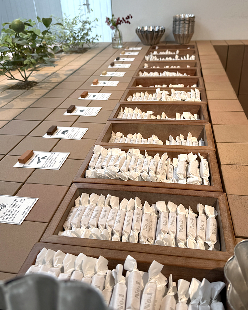 View of the different kinds of caramels available at Number Sugar. The caramels are long, pinkie-shaped caramels wrapped in white wax paper, flavor number written in a retro typeface.