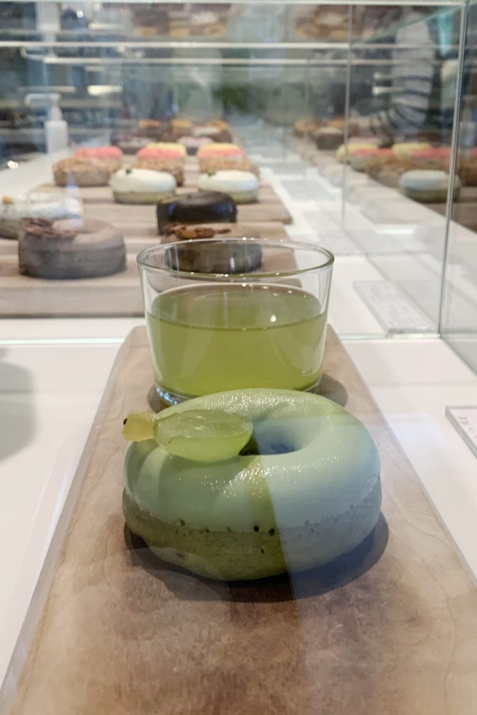 A line of elegant donuts in a display case styled with Japanese miminalism.